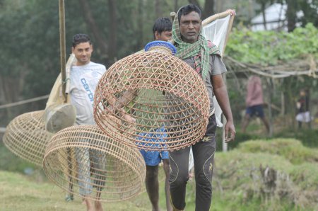Foto de 15 enero 2024 Bangladesh: Pueblos rurales armados con trampas de bambú y red de pesca artesanal participan en un festival de pesca de polo bawa de 100 años de duración en el beel Gowahori de Biswanath upazila de Sylhet, Bangladesh. - Imagen libre de derechos
