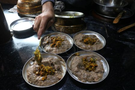 Téléchargez les photos : 18 janvier 2024, Srinagar Cachemire, Inde : Un chef garnit Harissa pour les clients par une matinée froide à Srinagar. Harissa est une recette de mouton ancienne unique préparée pendant les hivers au Cachemire. - en image libre de droit