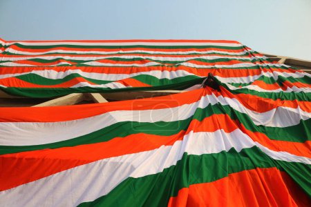 Téléchargez les photos : 23 janvier 2024, Srinagar Cachemire, Inde : Un employé du gouvernement drape la périphérie d'un stade intérieur avec un géant indien tri-couleur avant la fête de la République indienne à Srinagar - en image libre de droit