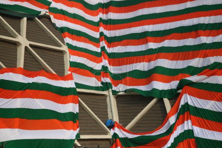 Téléchargez les photos : 23 janvier 2024, Srinagar Cachemire, Inde : Des employés du gouvernement drapent la périphérie d'un stade intérieur avec un géant indien tri-couleur avant la fête de la République indienne à Srinagar - en image libre de droit