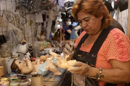 Téléchargez les photos : 23 janvier 2024, Mexico, Mexique : Les restaurateurs peignent ou soignent l'enfant de Dieu avant la Fiesta de la Candelaria sur la place de l'enfant de Dieu à Mexico - en image libre de droit