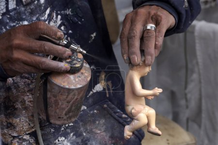 Téléchargez les photos : 23 janvier 2024, Mexico, Mexique : Les restaurateurs peignent ou soignent l'enfant de Dieu avant la Fiesta de la Candelaria sur la place de l'enfant de Dieu à Mexico - en image libre de droit
