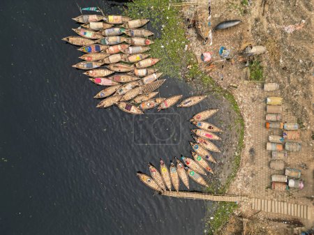 30 de enero de 2024, Dhaka, Bangladesh: Vista aérea de barcos de pasajeros de madera a lo largo del puerto del río Buriganga. Los barcos, adornados con coloridas alfombras estampadas, transportan a los trabajadores desde las afueras de la ciudad a su trabajo.