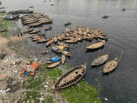Foto de 30 de enero de 2024, Dhaka, Bangladesh: Vista aérea de barcos de pasajeros de madera a lo largo del puerto del río Buriganga. Los barcos, adornados con coloridas alfombras estampadas, transportan a los trabajadores desde las afueras de la ciudad a su trabajo. - Imagen libre de derechos