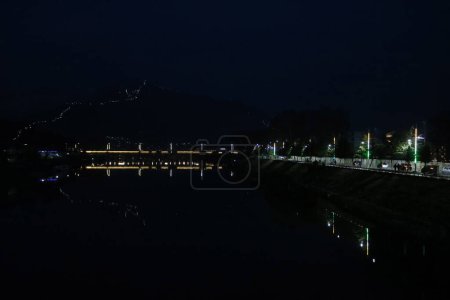 05 de marzo de 2024, Srinagar, India: Un puente iluminado se ve a través del río Jhelum por la noche en Srinagar