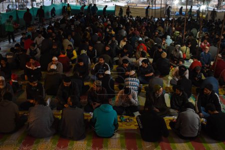 Téléchargez les photos : 19 mars 2024, Srinagar, Inde : Les musulmans du Cachemire rompent leur jeûne devant une mosquée pendant le mois sacré du Ramadan - en image libre de droit