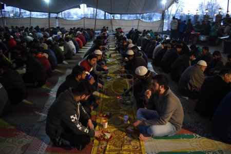 Téléchargez les photos : 19 mars 2024, Srinagar, Inde : Les musulmans du Cachemire rompent leur jeûne devant une mosquée pendant le mois sacré du Ramadan - en image libre de droit