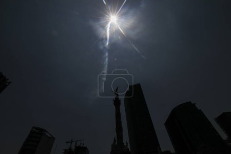 The sun is seen  through Angel de la Independencia Monument during the Great North American Solar Eclipse. Large crowds gather  the Angel de la Independencia in order to witness a partial eclipse of the sun. on April 8, 2024 in Mexico City, Mexico. (