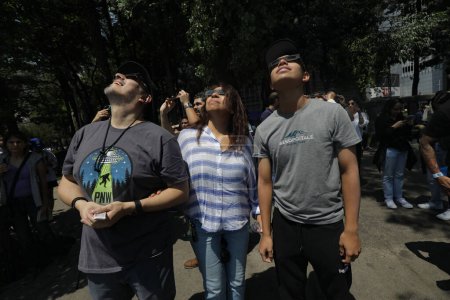 Foto de 9 de abril de 2024, Ciudad de México, México: Gente de la Ciudad de México se reunió en las cercanías del Ángel de la Independencia, para poder observar el eclipse parcial del sol, usaron lentes especiales - Imagen libre de derechos