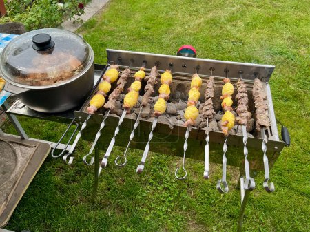 Photo for Automatic roasted meat and potatoes cooked at the barbecue with smoke - Royalty Free Image