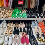 Shoes on sale in a mass market store, sorted by style. Different colours: green, orange, pink, gold, white, black and etc. High-quality photo
