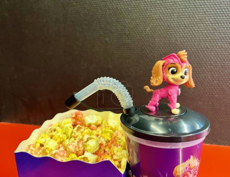 Photo for Cute toy Skye of Paw Patrol. Set of bucket popcorn and soft drink to promote the movie PAW Patrol: The Mighty Movie. High quality photo - Royalty Free Image