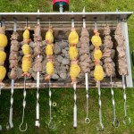 Automatic roasted meat and potatoes cooked at the barbecue with smoke