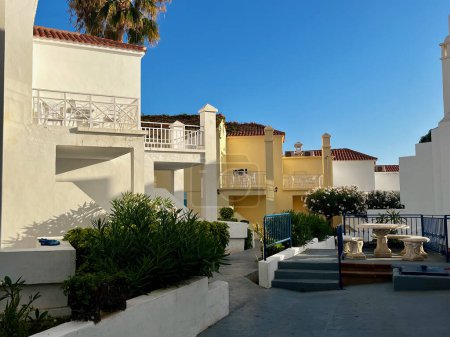 Foto de Apartamentos típicos de estilo canario y plantas tropicales. Increíble cielo azul. Foto de alta calidad - Imagen libre de derechos