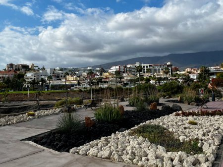 Playa del Duque, Tenerife, España - 17.05.2023: Vista de edificios de arquitectura, palmeras tropicales, nubes. Bufadero. Foto de alta calidad. Islas Canarias