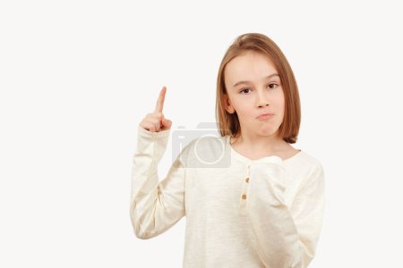 Photo for Young teen boy with long hair posing at studio. Guy pointing up at empty space. Boy gesturing new idea. Emotional portrait of happy teen boy over white background with copy space. - Royalty Free Image