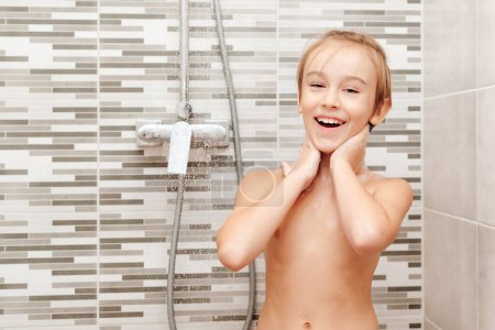 Foto de Lindo niño lavándose en la ducha. Feliz chico teniendo una ducha en el baño. Infancia saludable, concepto de estilo de vida. - Imagen libre de derechos