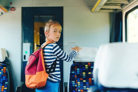 Photo for Schoolboy leaving wagon. Cute preteen boy getting off train. Little passenger standing inside train. Train arrival, departure. - Royalty Free Image