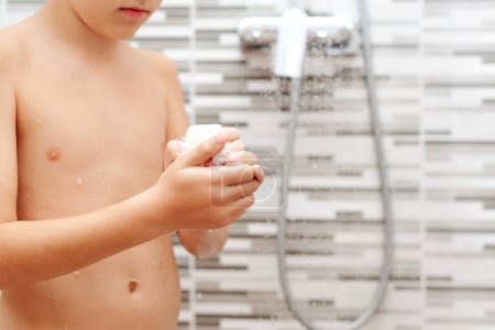 Téléchargez les photos : Garçon se laver sous la douche. Enfance saine, concept de mode de vie. - en image libre de droit