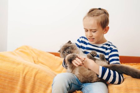 Photo for Happy kid hugging his cat. Boy relaxing on the bed with pet. Childhood, true friendship and home pet. Cute boy plays with a cat at home. - Royalty Free Image