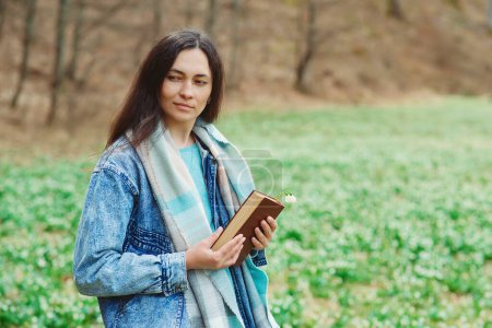 Photo for Woman enjoying spring day at nature. Lifestyle, people and spring time. Young woman with book on the walk. Time for reading. Reading book concept. - Royalty Free Image