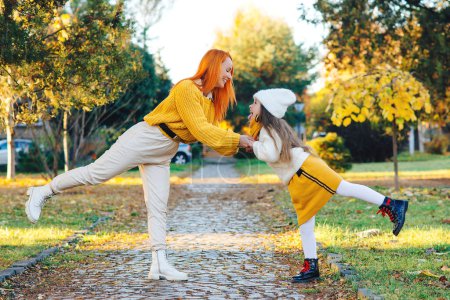 Photo for Lovely girl with her mom having fun on the walk. Autumn holidays, lifestyle. Happy family enjoying autumn weather in the park. - Royalty Free Image