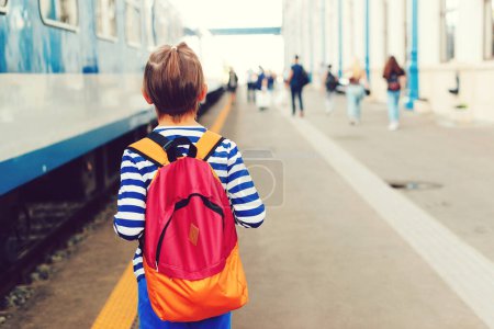 Photo for Boy waiting for express train on railway station platform. Kid with backpack on a subway. Travel, tourism, vacation and family concept. - Royalty Free Image