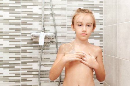 Téléchargez les photos : Mignon enfant se laver sous la douche. Joyeux garçon qui prend une douche dans la salle de bain. Enfance saine, concept de mode de vie. - en image libre de droit