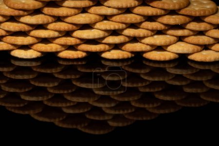 Photo for Crackers stacked to make a wall, foreground wall with reflection black background and space for text - Royalty Free Image