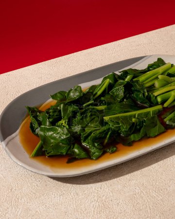 Nourriture chinoise asiatique cuite sur la table, plat simple. Bébé kailan frit avec sauce aux huîtres. nourriture verte végétarienne.
