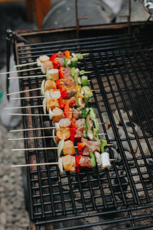 Des tranches de viande juteuses accompagnées de sauce et de légumes sont cuites sur un feu ouvert. Les collations sont cuites sur un gril métallique et prêtes à être servies