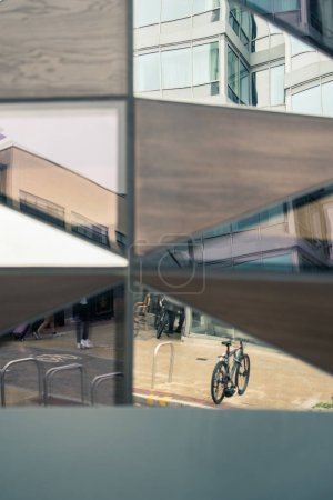 Photo for The facade of a building reflects bicycles, street and building - Royalty Free Image