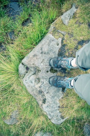 Photo for A person with wet shoes stands on a stone. The camera's gaze is directed downwards from a first-person perspective. - Royalty Free Image