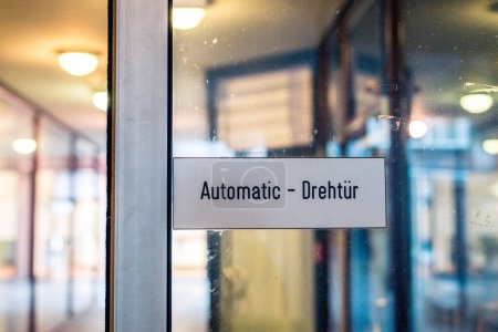 Photo for On an automatic entrance door of a shopping centre it says "Automatic - revolving door". - Royalty Free Image