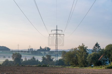 Photo for Power line in a beautiful landscape with early morning fog - Royalty Free Image