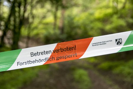 Photo for Flutter tape in the middle of the forest with the inscription: "Do not enter! Closed by forestry authorities" NRW - Royalty Free Image