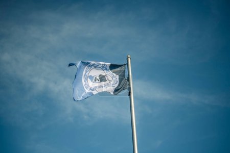 Photo for Waving Arminia Bielefeld flag against blue sky - Royalty Free Image