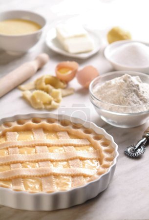 Téléchargez les photos : Tarte sucrée non cuite sur plaque, fabriquée en Italie avec des ingrédients sur le comptoir de cuisine - en image libre de droit