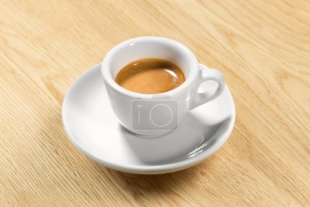 Foto de Café espresso italiano sobre mesa de madera Café árabe cremoso original en taza de mármol blanco tradicional, con sombra, enfoque en la crema Macro de primer plano detallado, alta resolución - Imagen libre de derechos