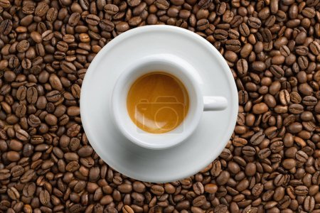 Foto de Café espresso italiano, vista superior fondo de granos de café.Taza espresso tradicional de cerámica blanca con una sombra de fundición, centrada en la crema, detallada, plano macro de primer plano, de alta resolución. - Imagen libre de derechos