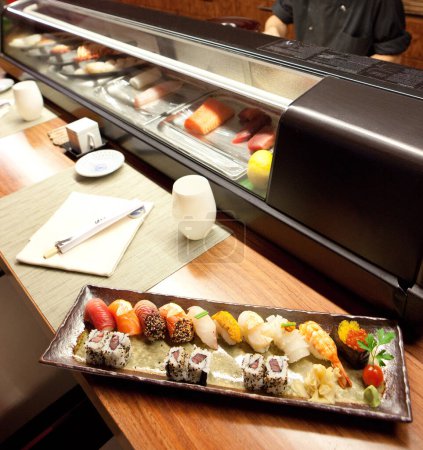 Téléchargez les photos : Sushi dans les aliments japonais Restaurant Cuisine Machine Flou fond, Assiette avec sauce soja, Rangée de Nigiri et rouleaux avec Wasabi, Caviar rouge, Dîner gastronomique sur napperons haute définition Vue du dessus - en image libre de droit