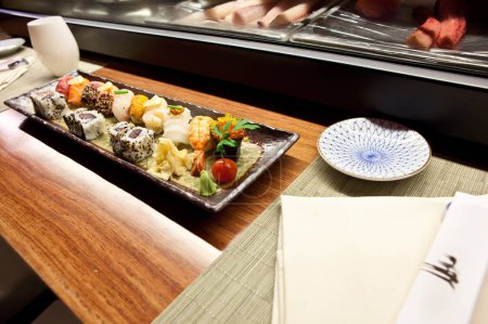 Téléchargez les photos : Sushi dans la cuisine japonaise de restaurant de nourriture servant le fond, plat avec la sauce de soja, rangée de Nigiri et des rouleaux avec Wasabi, caviar rouge, dîner gastronomique sur napperons détaillé, haute résolution Gros plan - en image libre de droit