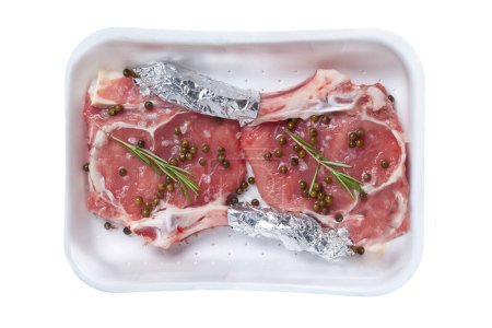Téléchargez les photos : Steaks d'agneau (Recette italienne "Scottadito") Conteneur à emporter avec poivre vert et romarin isolés sur fond blanc - en image libre de droit