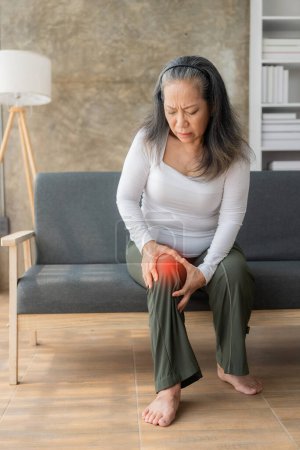 Foto de Dolor de rodilla, mujer mayor asiática de cerca Mujer mayor madura tocando la articulación de la rodilla que sufre de dolor de rodilla en el hospital. Problemas de salud. La vejez. Problemas de salud. - Imagen libre de derechos