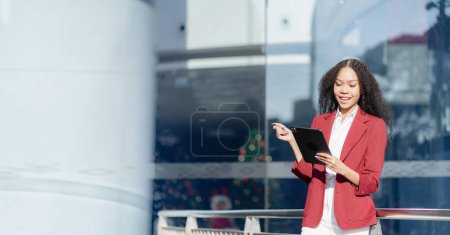 Photo for Happy young businesswoman in city using tablet computer and working Cute woman in smart casual using digital tablet outdoors - Royalty Free Image