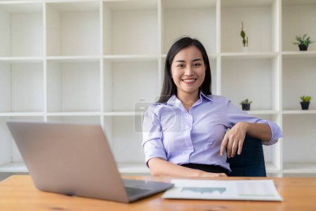 Téléchargez les photos : Femme asiatique travaillant avec des documents financiers et ordinateur portable au bureau, concept de comptabilité financière - en image libre de droit