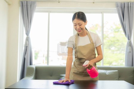 Téléchargez les photos : Jeune femme asiatique appréciant le nettoyage de printemps dans la maison ou l'appartement, les travaux ménagers et le concept d'entretien ménager - Heureuse femme asiatique ou femme au foyer avec une serpillière nettoyant la maison. - en image libre de droit