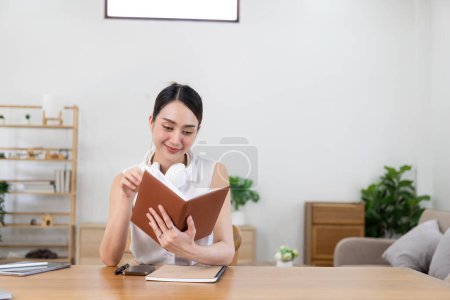 Photo for Beautiful Asian woman and headphones use laptop at home to write notes Attractive female student learning language Watch the webinar online online internet education - Royalty Free Image