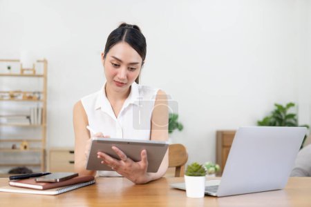 Photo for Smiling business woman working in home office with laptop and tablet, happy Asian woman Girl with digital device interacting with customers, banner copy space - Royalty Free Image