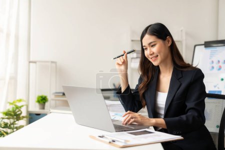 Téléchargez les photos : Femme d'affaires asiatique travaillant avec ordinateur portable et tableaux d'analyse au travail, finances d'entreprise et rapport financier, investissement de plan d'affaires, - en image libre de droit